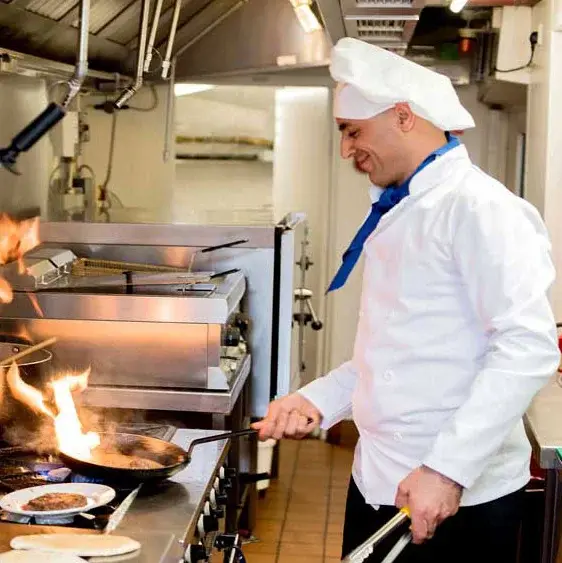 Osprey Heights Chef Created Meals, chef frying a dish.