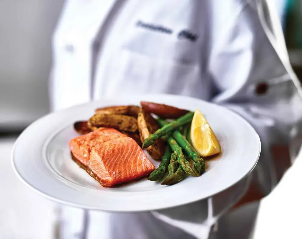 Osprey Heights Chef Created Meals, chef delivering a finished dish.